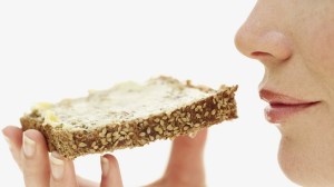 side profile of a young woman holding a piece of sesame seed toast